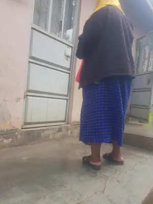 a woman is standing in front of a door at othman homes in Arusha