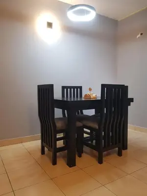 a dining room table with two chairs and a table with lights at othman homes in Arusha