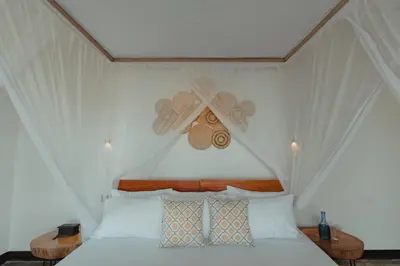a bedroom with a white bed with a ceiling at Foot On Africa Safari Lodge in Mto wa Mbu