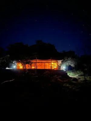 a house lit up at night with lights at Namayana Camp in Makama