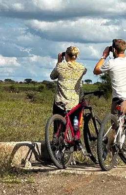 two people taking pictures of a person on a bike at Namayana Camp in Makama