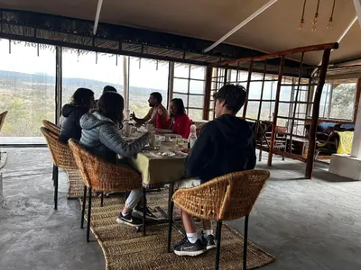 a group of people sitting at a table in a restaurant at Namayana Camp in Makama