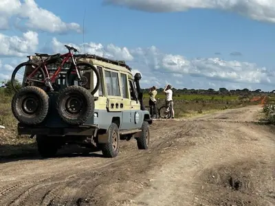 a jeep with a bike on the back on a dirt road at Namayana Camp in Makama