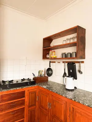 a kitchen with wooden cabinets and a counter top at Arusha backpackers homes in Arusha
