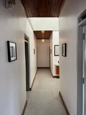 a hallway with white walls and a wooden ceiling at Arusha backpackers homes in Arusha