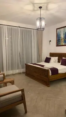 a bedroom with two beds and a chandelier at Casa Laurensana in Arusha