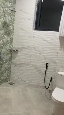 a bathroom with a toilet and a wall at Casa Laurensana in Arusha