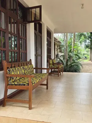 a porch with a bench and chairs on it at Sprunger Retreat - tulia homes in Moshi