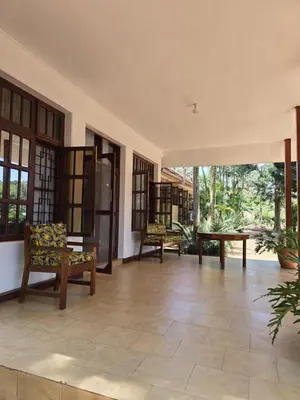 a living room with chairs and a table at Sprunger Retreat - tulia homes in Moshi