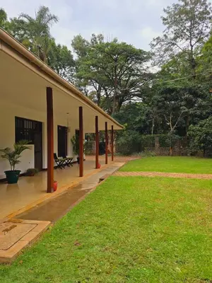 a house with a grass yard next to a building at Sprunger Retreat - tulia homes in Moshi