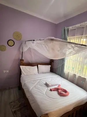 a bed with two pink shoes sitting on it at Bushline Retreat in Karatu
