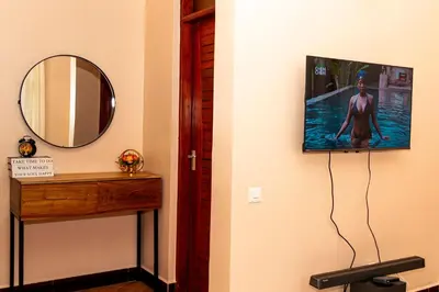 a mirror on a wall with a woman on it at Neylisa Apartments in Arusha