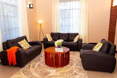 a living room with two couches and a table at Neylisa Apartments in Arusha