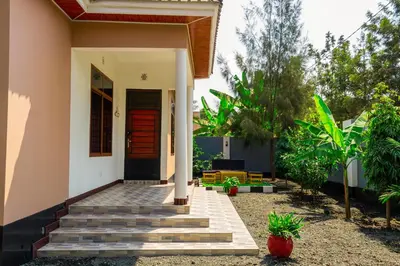 a house with a red door and stairs in front at Neylisa Apartments in Arusha