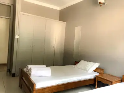 a small bedroom with a bed and a cabinet at Moshi Green Lodge in Moshi