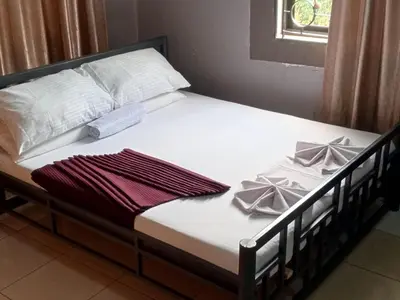 a bed with white sheets and bows on it at Moshi Green Lodge in Moshi