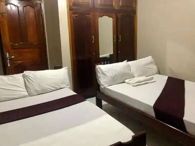 two beds sitting next to each other in a room at Moshi Green Lodge in Moshi