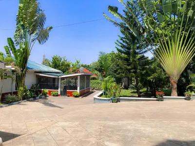 a house with a courtyard with palm trees at Moshi Green Lodge in Moshi