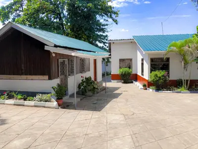 a building with a blue roof and a patio at Moshi Green Lodge in Moshi
