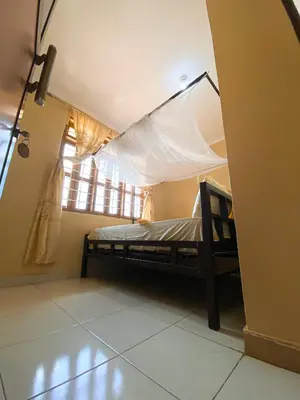 a bedroom with a bed in a room with a window at Kinyaiya's Sereniry Farmstay