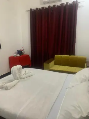 a bedroom with a large bed and a red curtain at Hill Park Lodge Moshi in Shiri