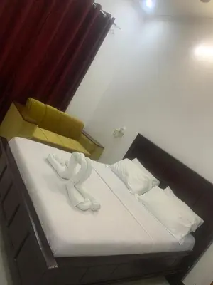 a bed with two white towels on top of it at Hill Park Lodge Moshi in Shiri