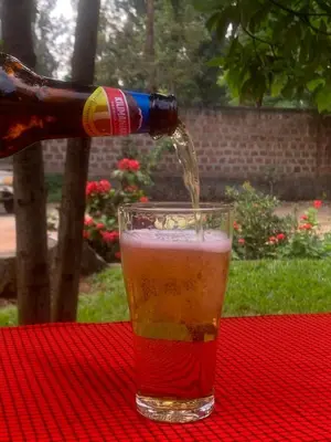 a drink is being poured into a glass on a table at Hill Park Lodge Moshi in Shiri
