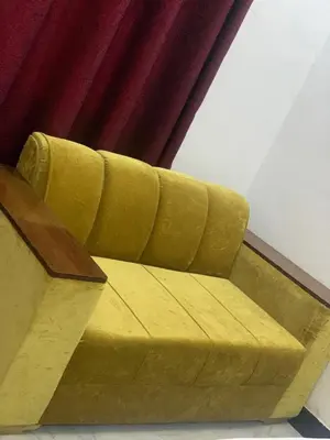 a yellow couch sitting in front of a curtain at Hill Park Lodge Moshi in Shiri