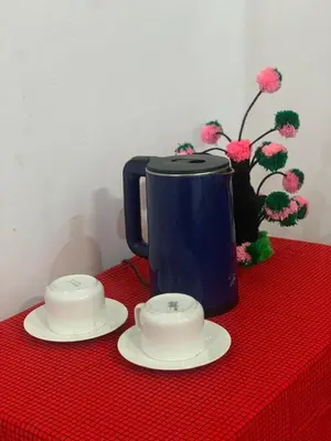 a red table with a blue coffee pot and two plates at Hill Park Lodge Moshi in Shiri