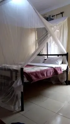 a bunk bed with a canopy in a room at Arusha Sunbird Lodge in Arusha