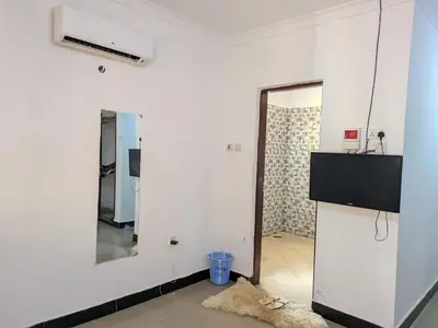 a white room with a refrigerator and a mirror at Arusha Sunbird Lodge in Arusha