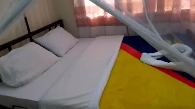 a small bed in a small room with a canopy at Arusha Sunbird Lodge in Arusha
