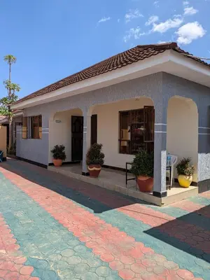 a small building with potted plants on the outside at Arusha Sunbird Lodge in Arusha