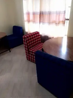 a living room with a couch and a table and chairs at Arusha Sunbird Lodge in Arusha