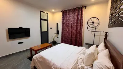a bedroom with a bed and a flat screen tv at Domin Homestay in Arusha