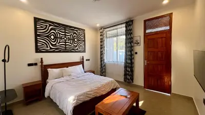 a bedroom with a bed and a wooden door at Domin Homestay in Arusha