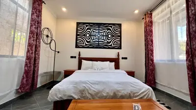 a bedroom with a bed and a painting on the wall at Domin Homestay in Arusha