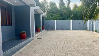 a blue house with a fence and potted plants at Domin Homestay in Arusha