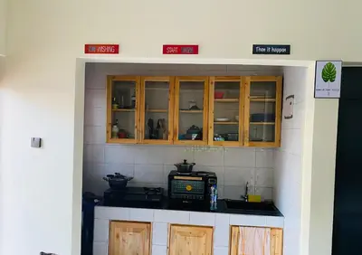 a kitchen with wooden cabinets and a microwave at Blessings Home in Arusha
