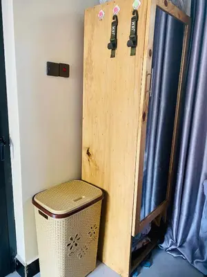a wooden door in a room with a trash can at Blessings Home in Arusha