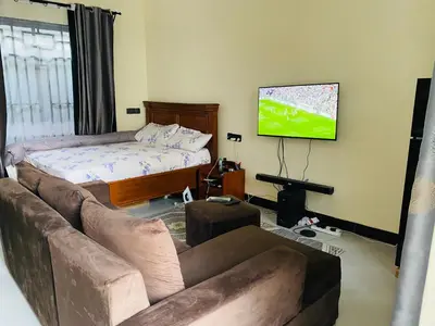 a living room with a couch and a flat screen tv at Blessings Home in Arusha