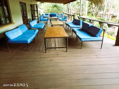 a row of blue chairs and tables on a deck at Africa Sky Lodge, Bar and Restaurant in Karatu