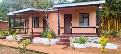 a small pink house with a porch at Africa Sky Lodge, Bar and Restaurant in Karatu