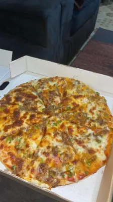 a large pizza in a box on a table at Africa Sky Lodge, Bar and Restaurant in Karatu