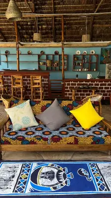 a bed with colorful pillows on it in a room at Amoy River Lodge in Moshi