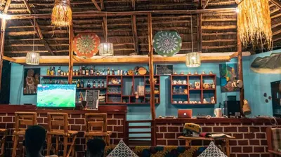 a restaurant with a bar with a tv in it at Amoy River Lodge in Moshi