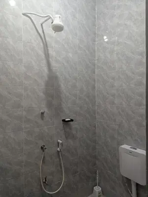 a bathroom with a shower with a shower head at Utulivu Home Stay Apartment in Arusha