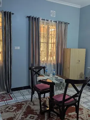 a dining room with a table and two chairs at Utulivu Home Stay Apartment in Arusha