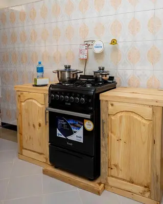 a kitchen with a stove with pots and pans on it at Richard's Road Homestay in Boma la Ngombe