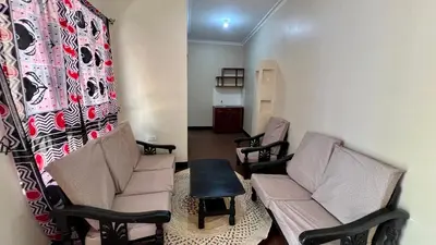a living room with two chairs and a couch at Kwetu Villa in Arusha
